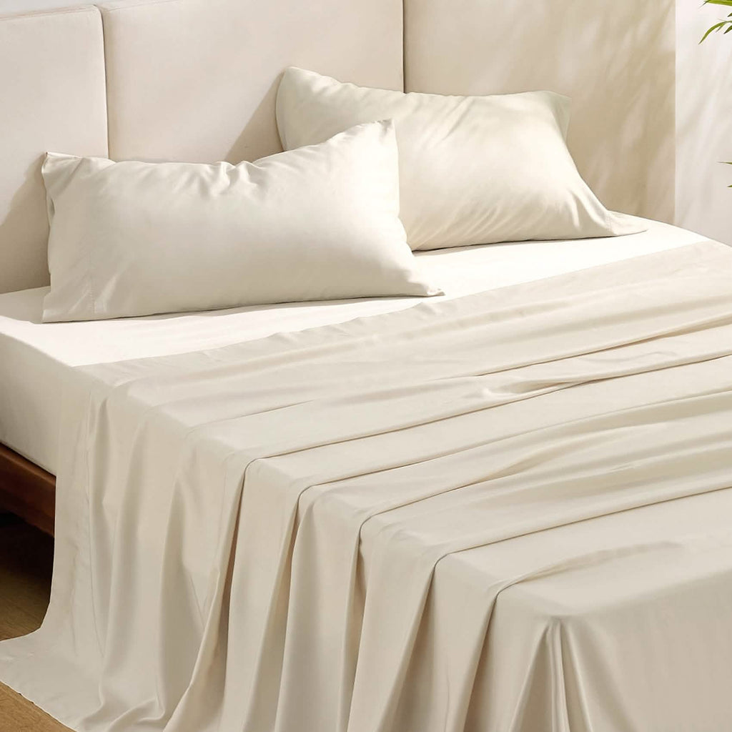 Beige GentleSoft rayon from bamboo sheet set with two pillowcases on a bed, showcasing silky texture and drape.