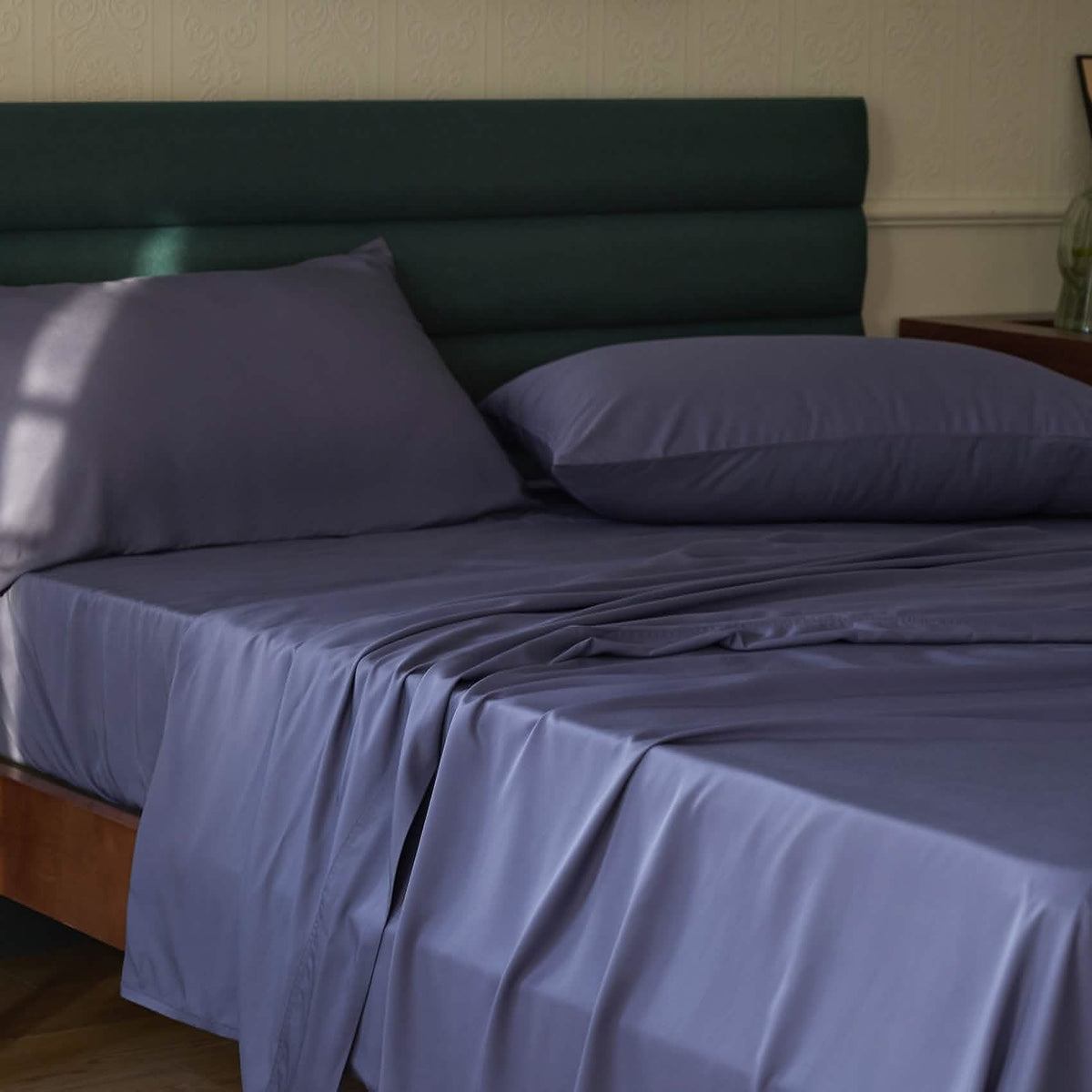 Deep indigo GentleSoft rayon bamboo cooling sheet set on a bed, showcasing silky texture and drape.