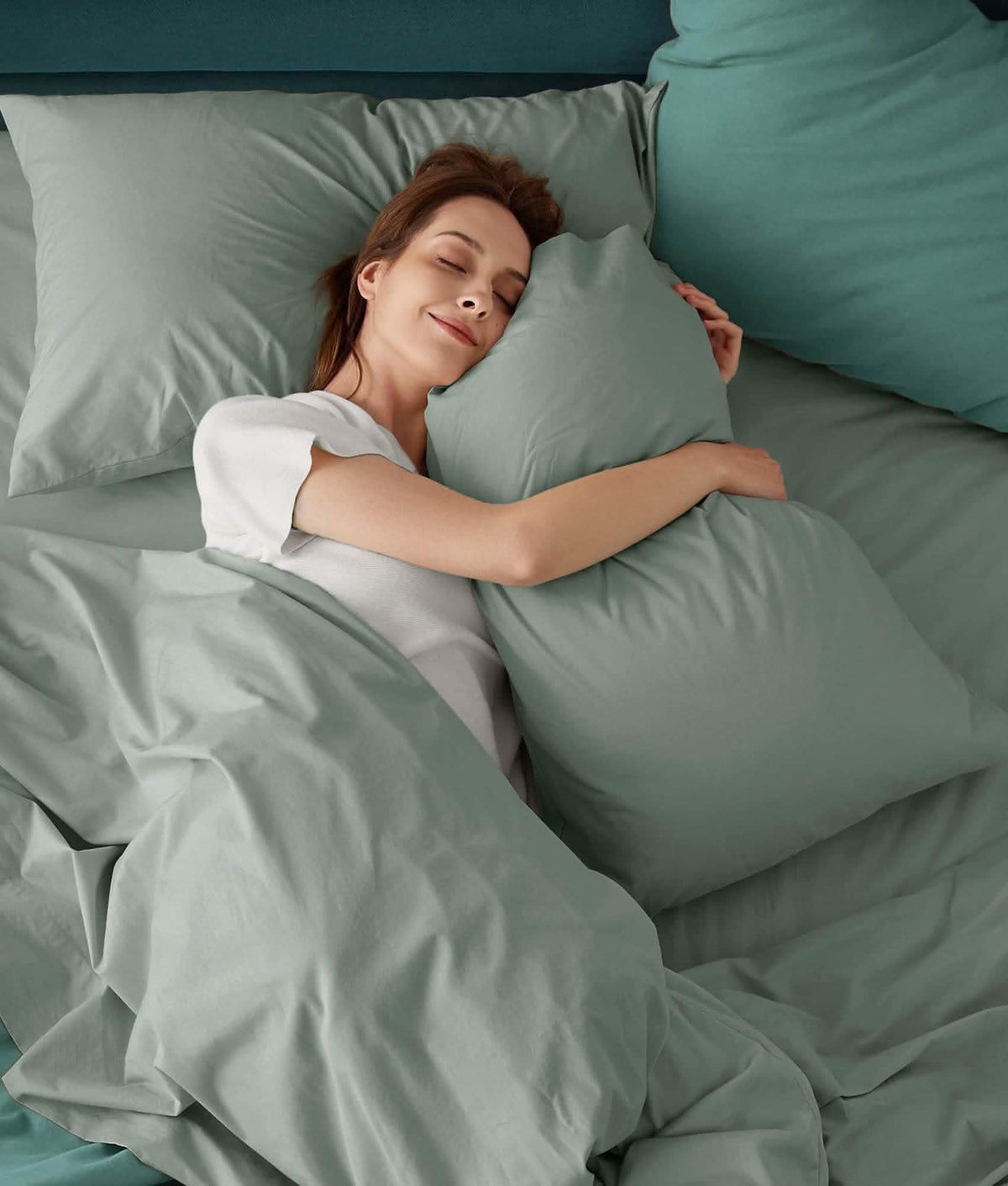 Peaceful woman sleeping on soft, light green 100% cotton percale weave sheet set.