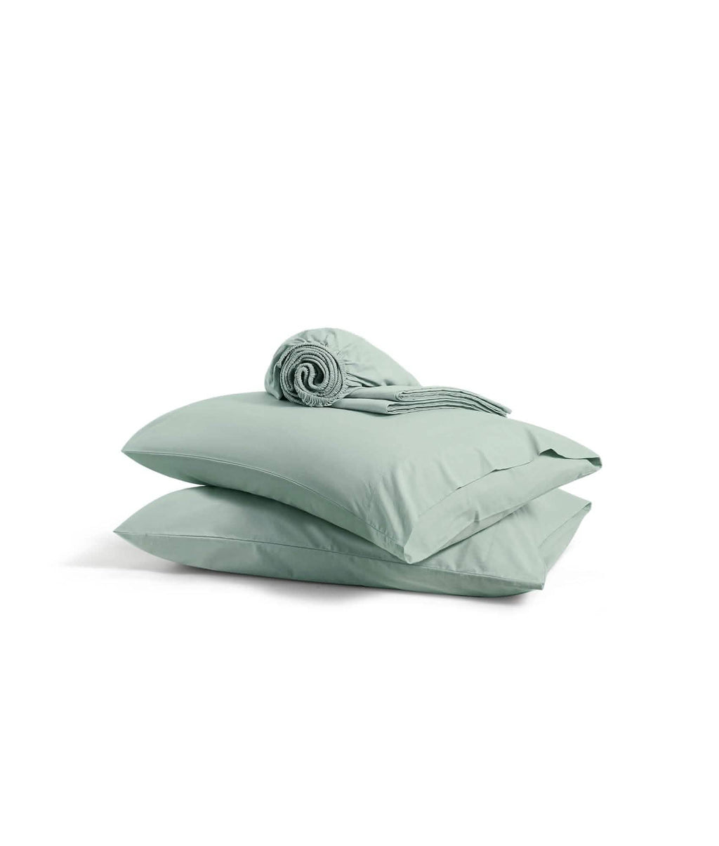 Stacked sage green pillowcases with rolled percale sheet, 100% cotton.