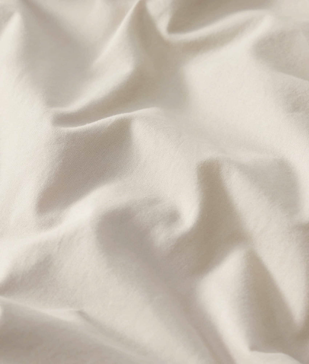 Soft, breathable cream cotton percale weave sheet set fabric texture.