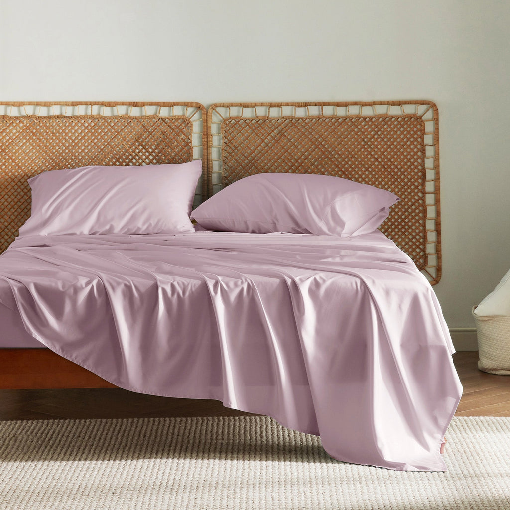 Dusty rose GentleSoft bamboo sheet set with pillowcases on a bed, showcasing silky texture and smooth finish.